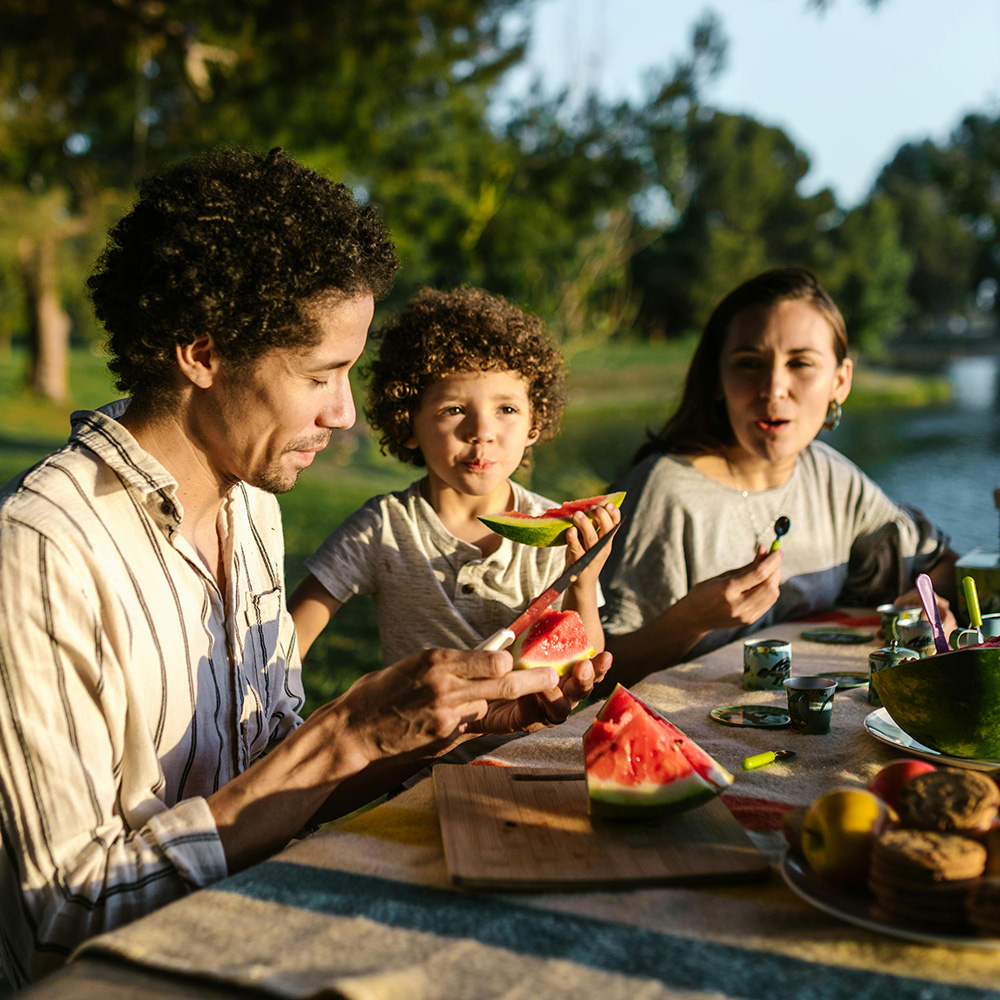 Familj som sitter och får d vitamin från solen
